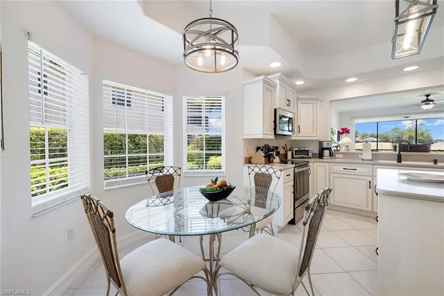 a kitchen with a dining table chairs and refrigerator
