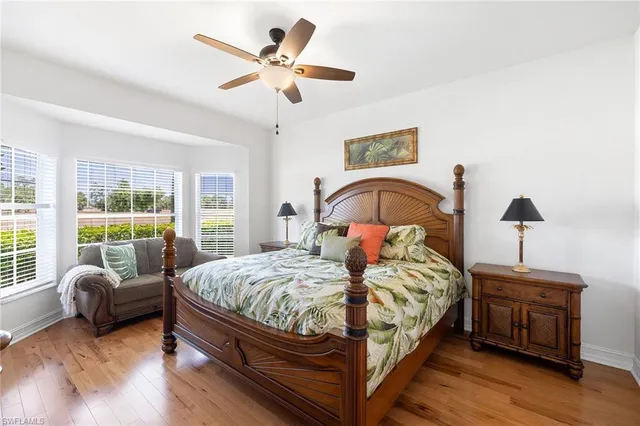 a bedroom with a bed a couch and a large window