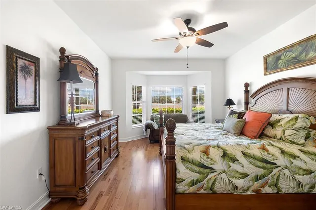 a bedroom with a bed dresser and wooden floor