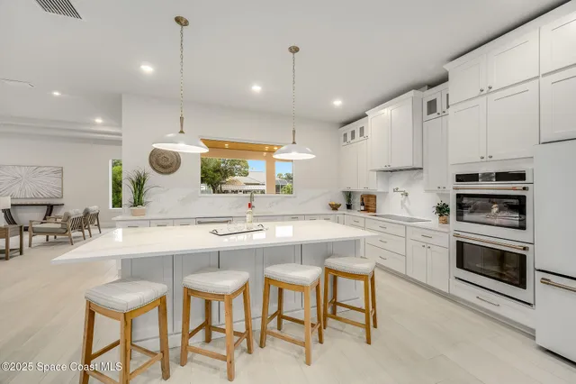 a large kitchen with kitchen island a large island in it