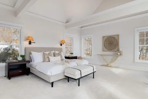 a bedroom with a bed lamp and paintings on the wall