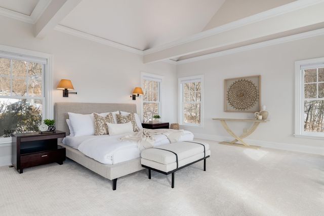 a bedroom with a bed lamp and paintings on the wall