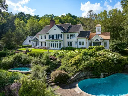 a view of a house with garden and trees