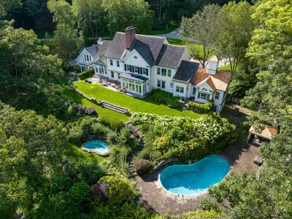 an aerial view of a house with a garden and lake view