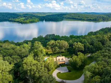 an aerial view of a residential houses with outdoor space and lake view