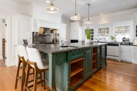 a kitchen with kitchen island granite countertop a sink counter and chairs