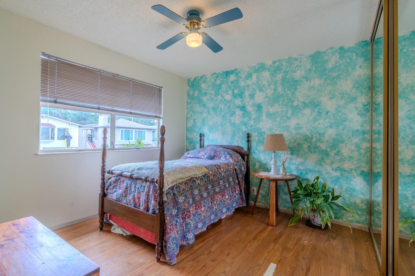 226 Crestmoor Circle Pacifica, CA 94044 - Photo 11 of 23 a bedroom with a bed and a chandelier