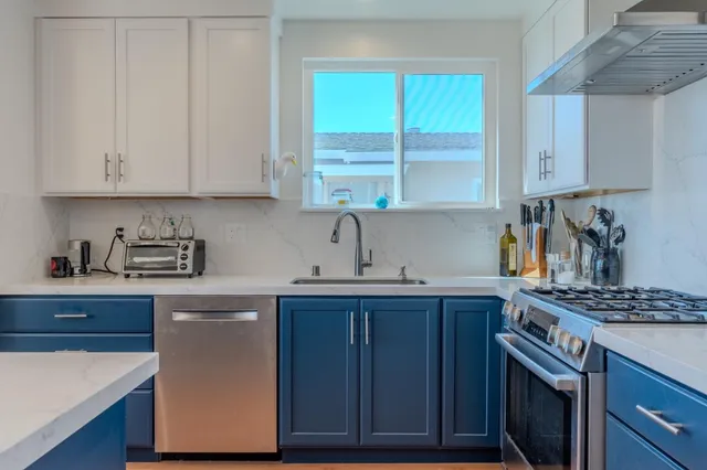 a kitchen with stainless steel appliances granite countertop a sink a stove and cabinets