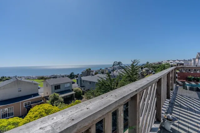 a balcony with wooden floor and city view