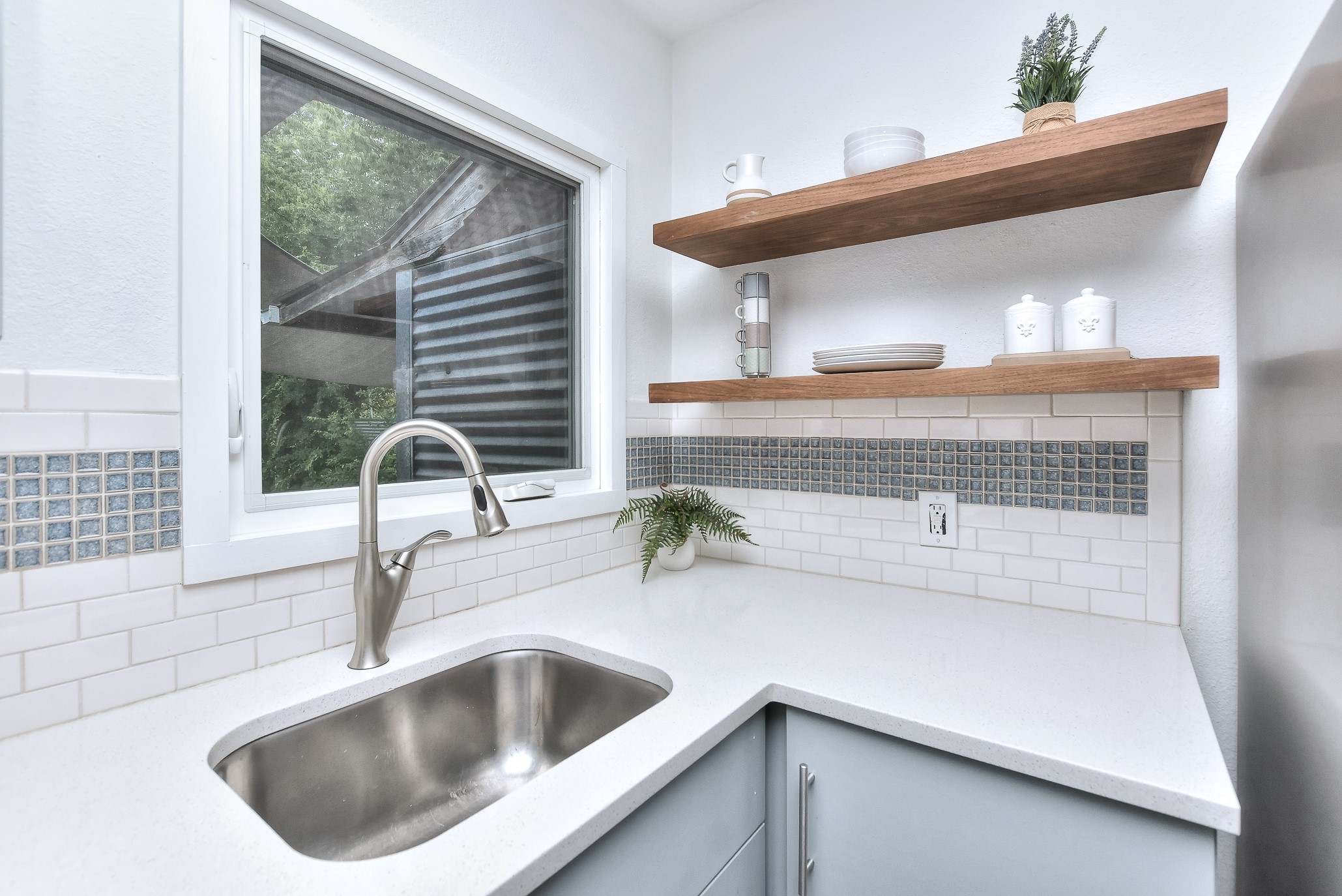 1309 Ridgemont Drive Austin, TX 78723 - Photo 13 of 35 Stainless farmhouse undermount sink with window overlooking the backyard. Windows were updated with energy efficient options in 2014. Note the beautiful custom tile backsplash!