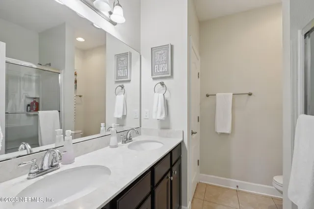a bathroom with double vanity sinks and a mirror