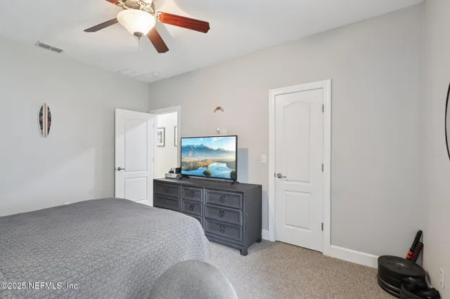 a bedroom with a bed and a flat tv screen on dresser