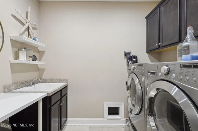 a utility room with sink dryer and washer