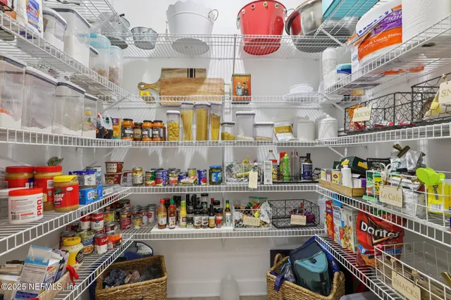 a store room with lots of clutter and stainless steel appliances