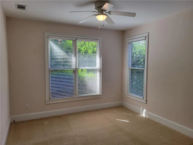 an empty room with a window and ceiling fan