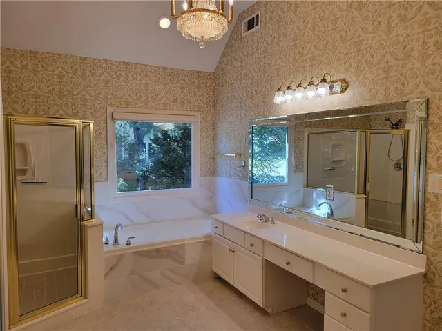 a spacious bathroom with a double vanity sink a mirror and a shower