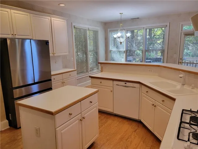 a kitchen with white cabinets and a refrigerator