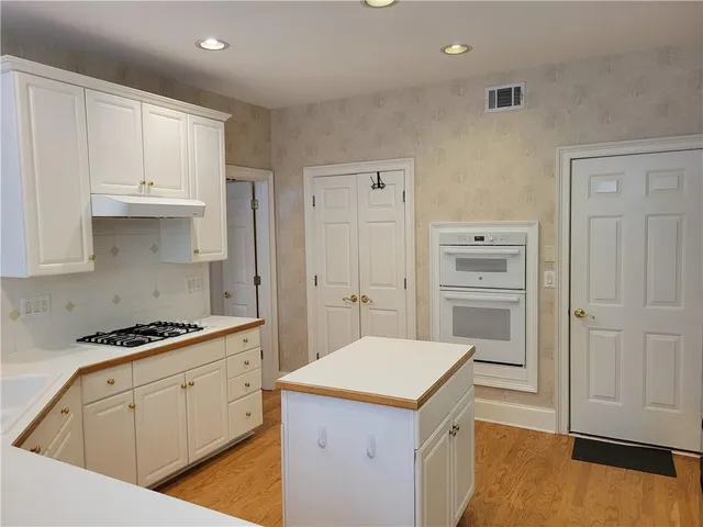 a kitchen with white cabinets and appliances