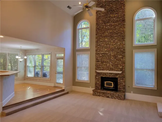 a view of an empty room with a fireplace and a window