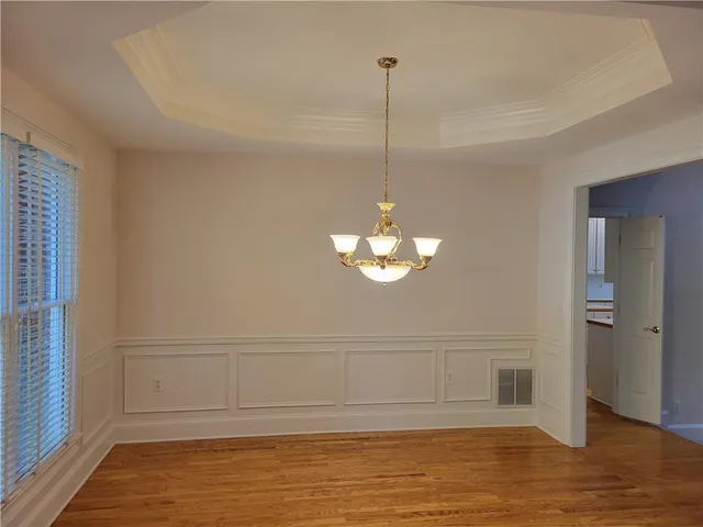 a view of a room with a chandelier fan and wooden floor