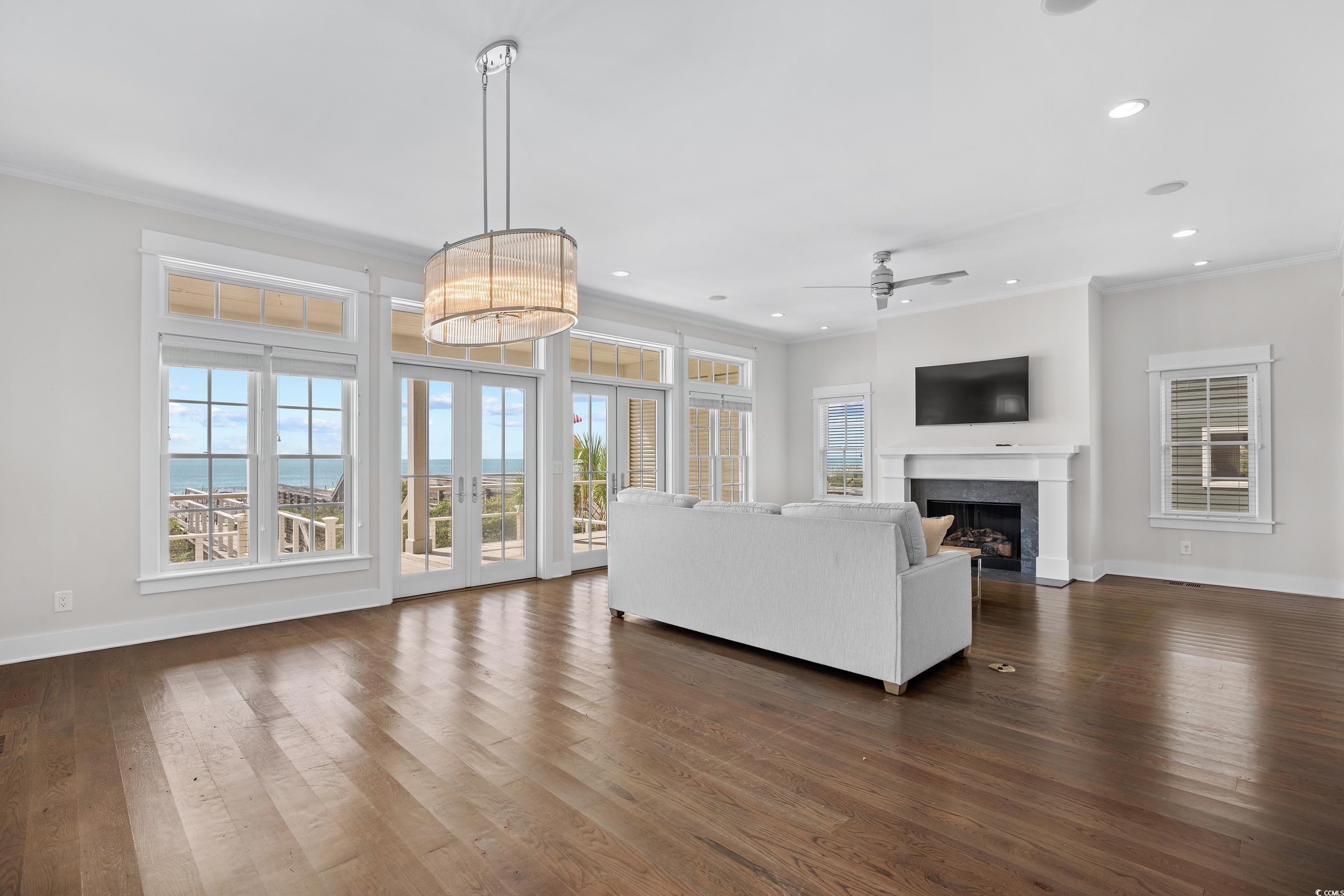 40 Seaview Loop Pawleys Island, SC 29585 - Photo 12 of 34 Living area with crown molding, dark wood-type flooring, french doors, a fireplace with flush hearth, and recessed lighting