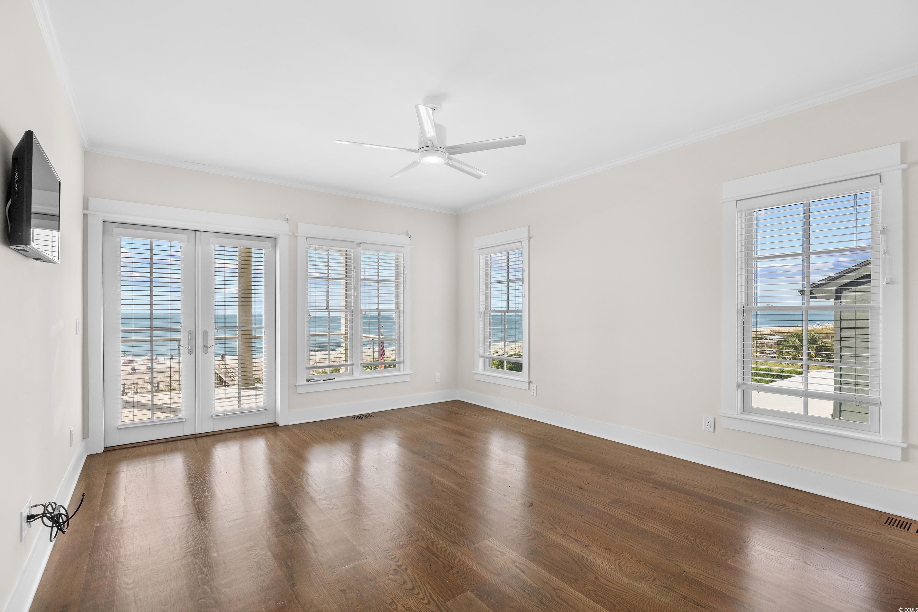 40 Seaview Loop Pawleys Island, SC 29585 - Photo 15 of 34 Unfurnished room with wood finished floors, crown molding, ceiling fan, and french doors