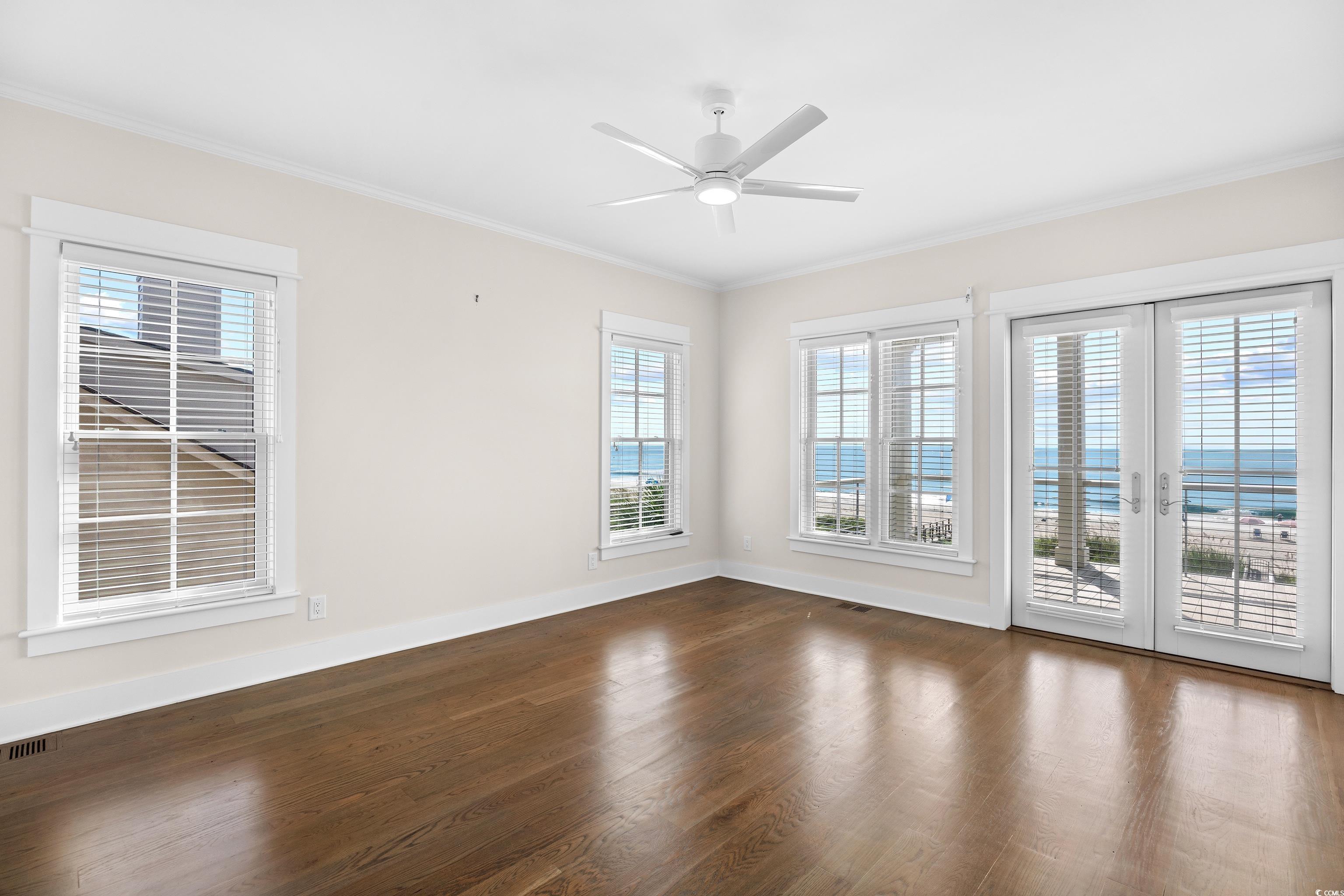 40 Seaview Loop Pawleys Island, SC 29585 - Photo 16 of 34 Empty room featuring healthy amount of natural light, ornamental molding, wood finished floors, and french doors