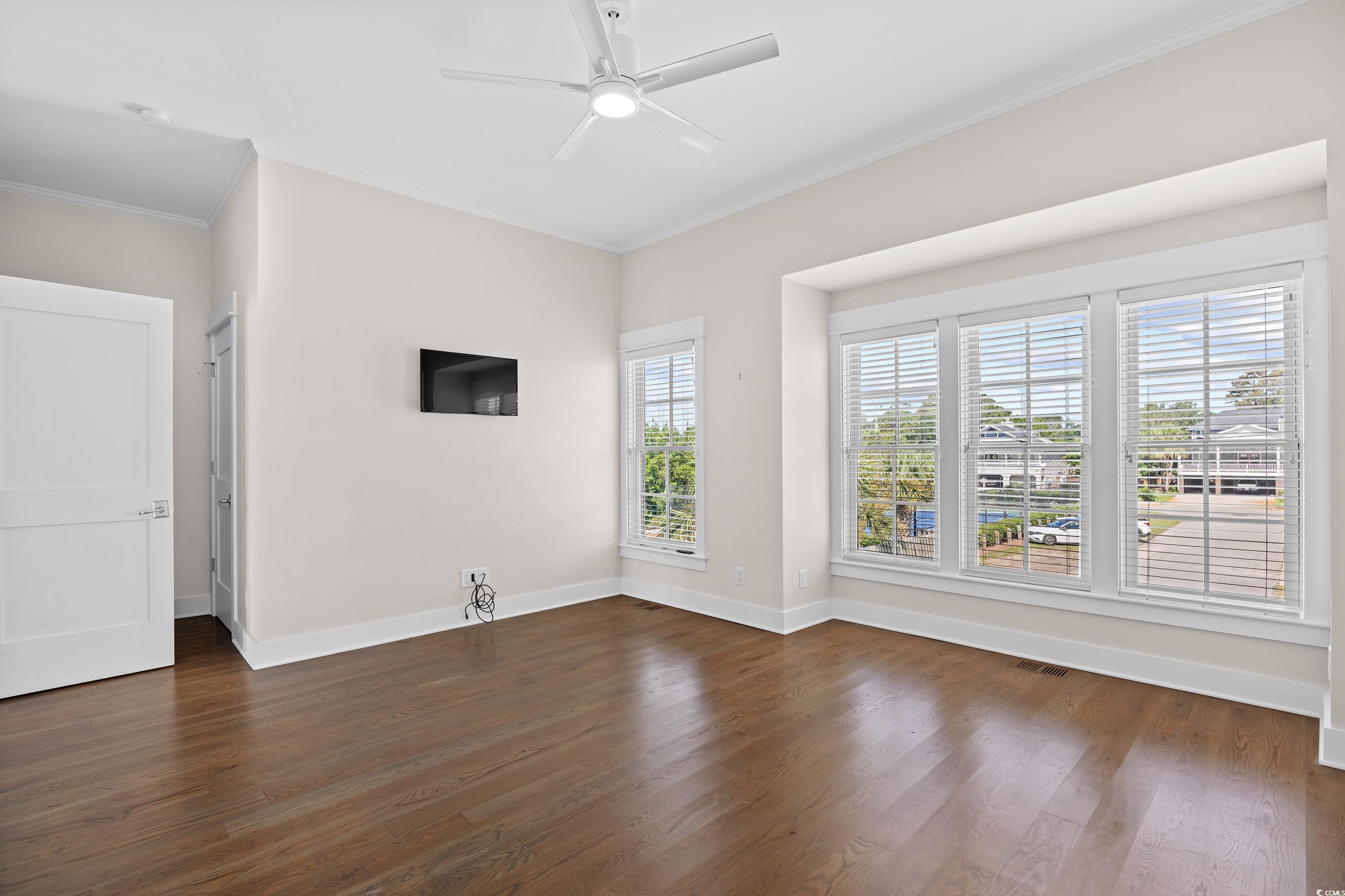 40 Seaview Loop Pawleys Island, SC 29585 - Photo 19 of 34 Spare room featuring ornamental molding, dark wood-style floors, and a ceiling fan