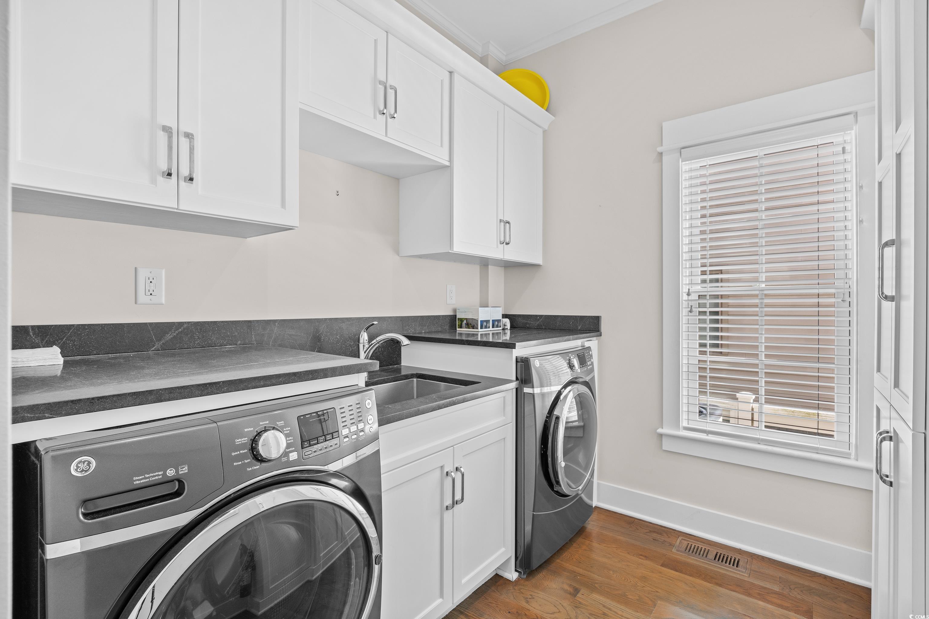 40 Seaview Loop Pawleys Island, SC 29585 - Photo 20 of 34 Washroom with dark wood-type flooring, cabinet space, ornamental molding, and washing machine and clothes dryer
