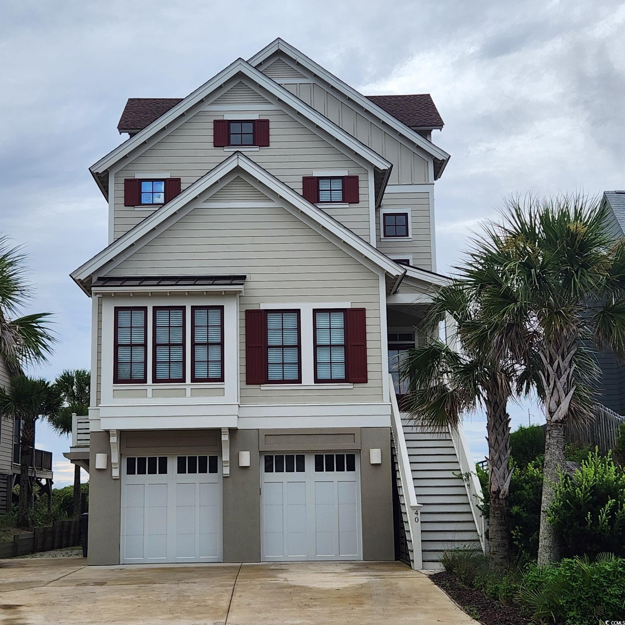 40 Seaview Loop Pawleys Island, SC 29585 - Photo 2 of 34 Raised beach house with concrete driveway, stairs, a garage, a shingled roof, and board and batten siding