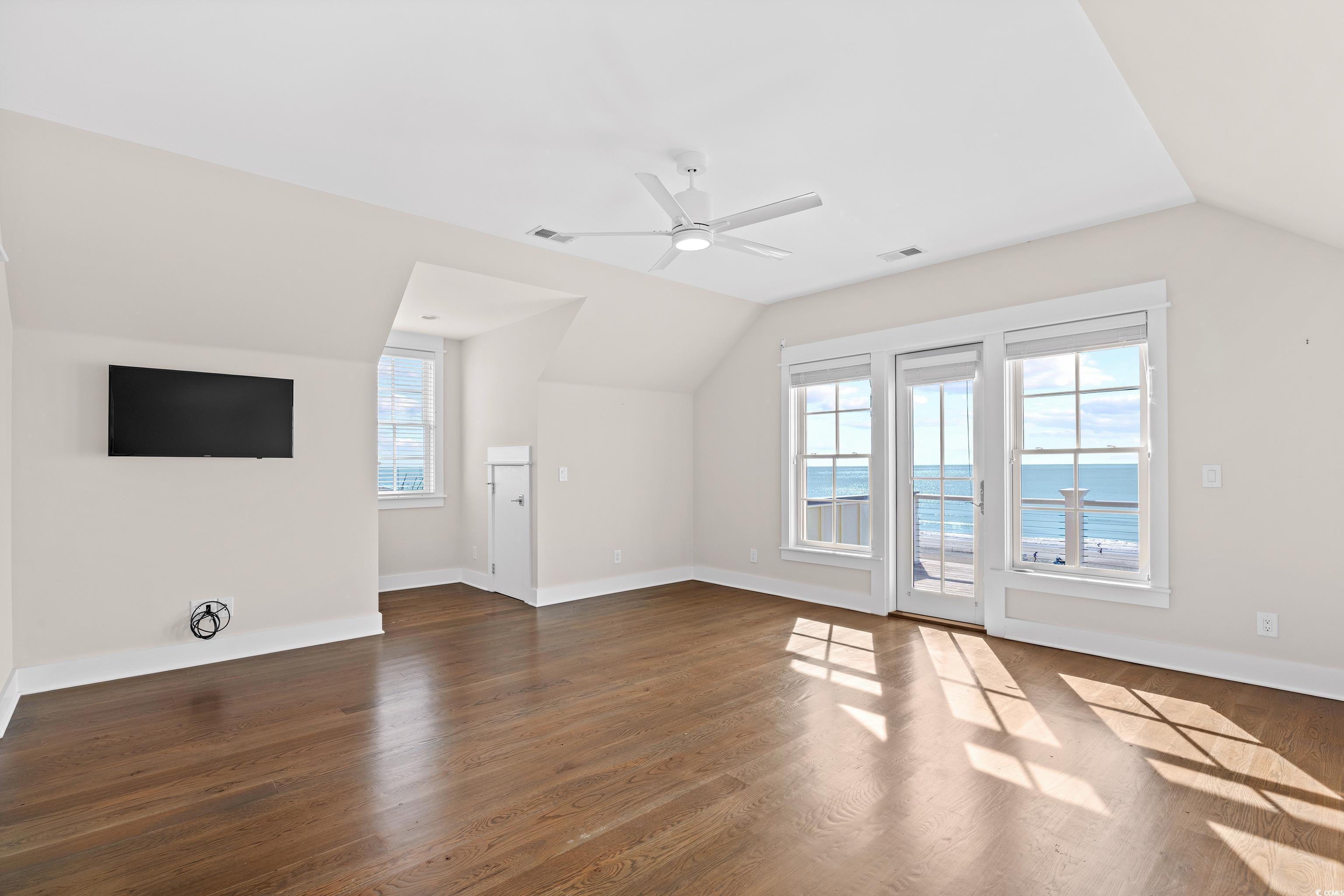40 Seaview Loop Pawleys Island, SC 29585 - Photo 21 of 34 Additional living space with vaulted ceiling, plenty of natural light, dark wood-type flooring, ceiling fan, and a water view