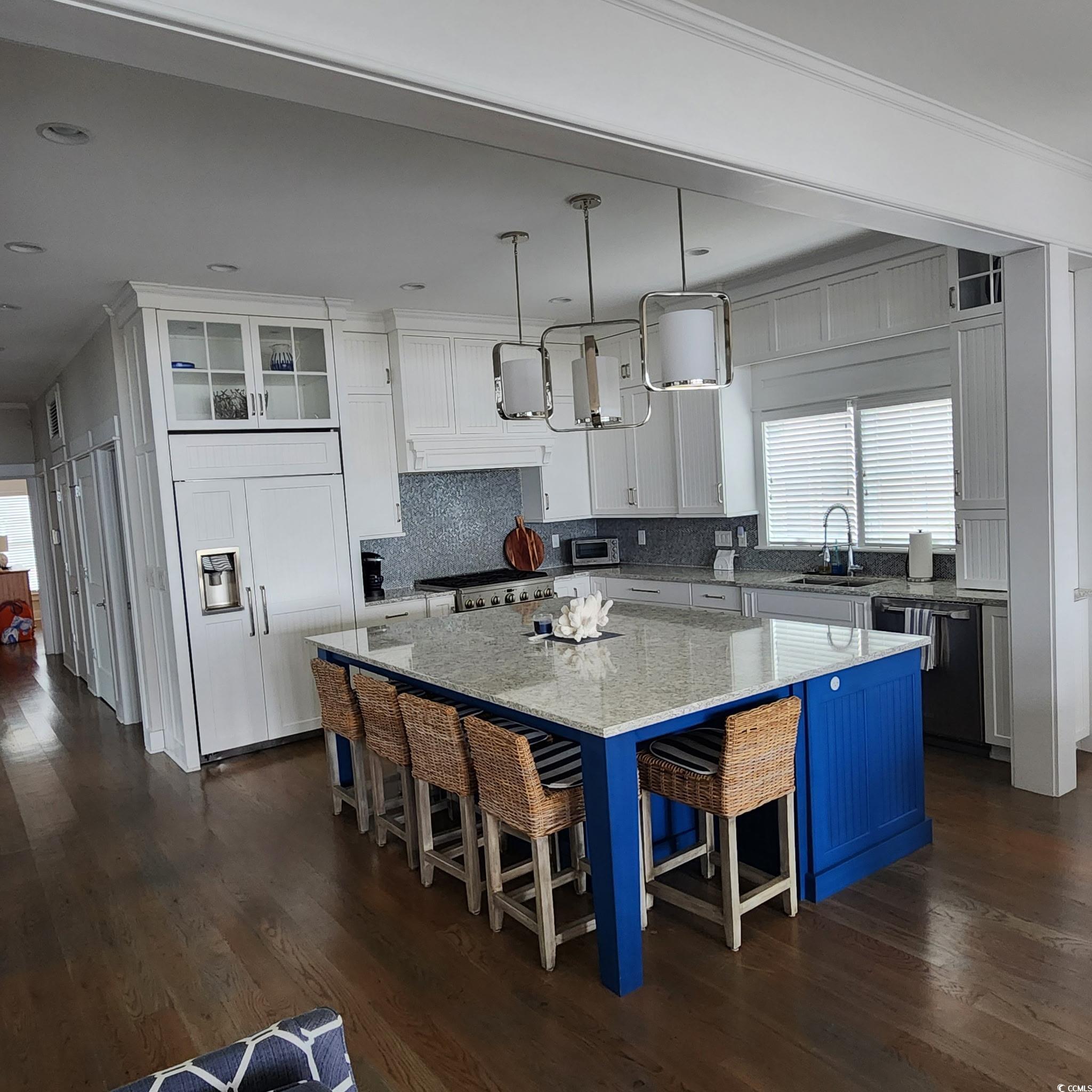 40 Seaview Loop Pawleys Island, SC 29585 - Photo 6 of 34 Kitchen with healthy amount of natural light, a kitchen breakfast bar, and white cabinetry