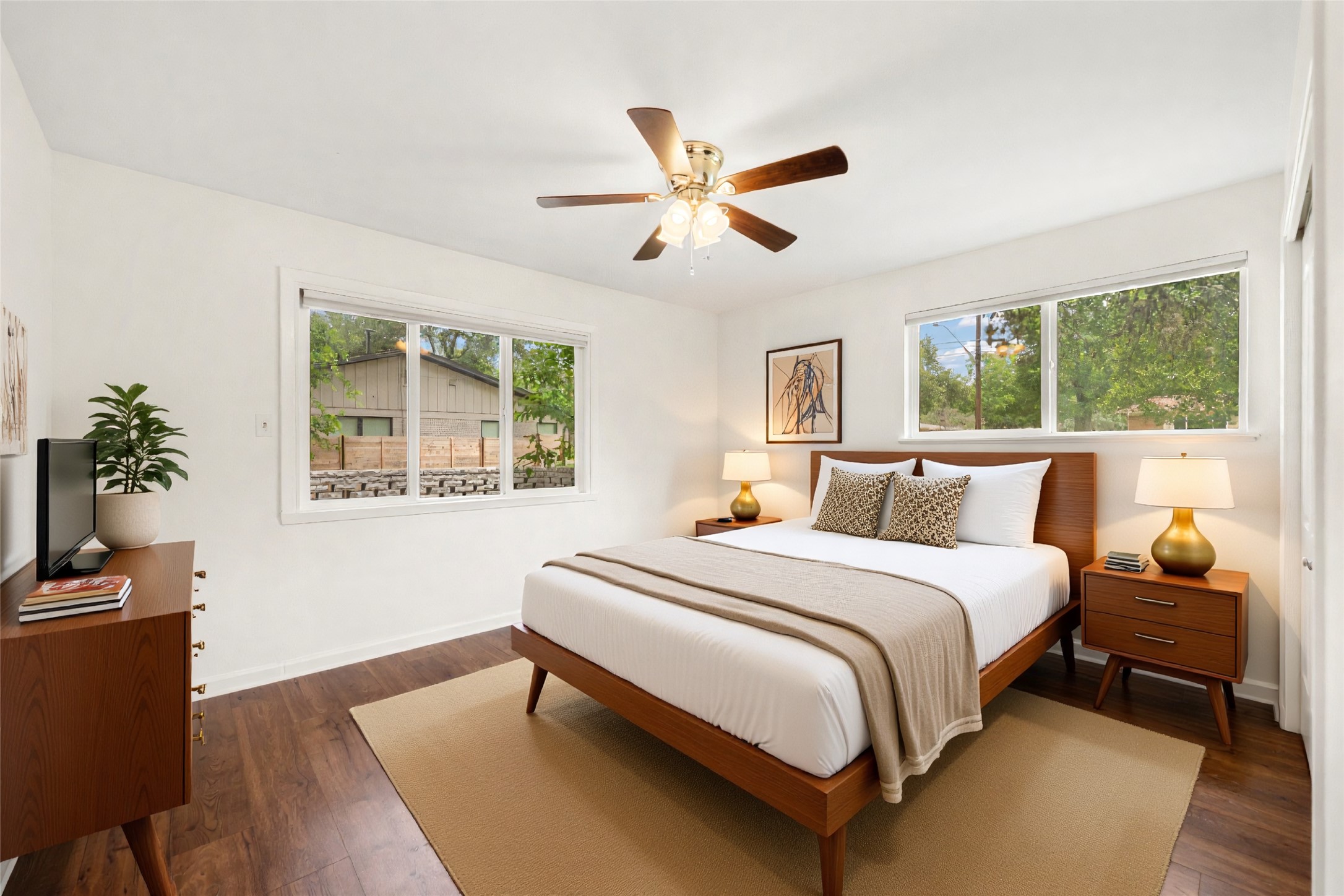 4602 Frontier Trail Austin, TX 78745 - Photo 9 of 21 The tranquil primary bedroom offers dark wood flooring, a ceiling fan, and abundant natural light from multiple windows.