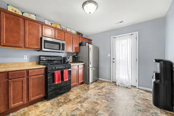 a kitchen with stainless steel appliances granite countertop a refrigerator stove and sink
