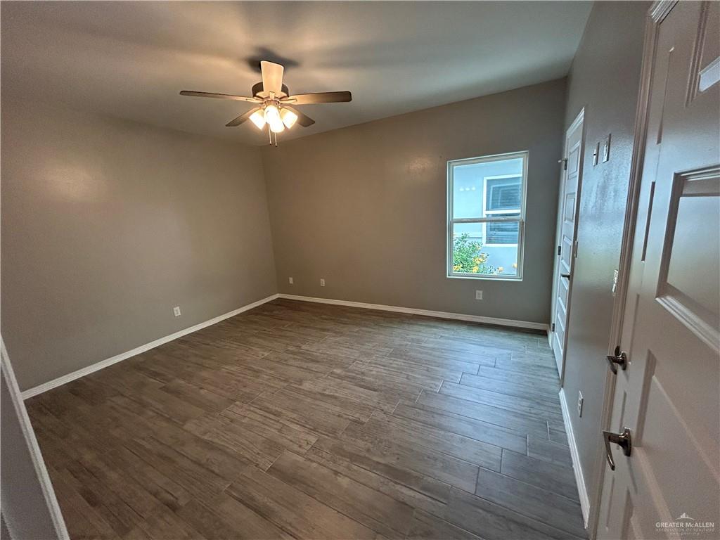 1805 Stauffers Street, Unit 1 Weslaco, TX 78596 - Photo 10 of 13 wooden floor in an empty room with a window