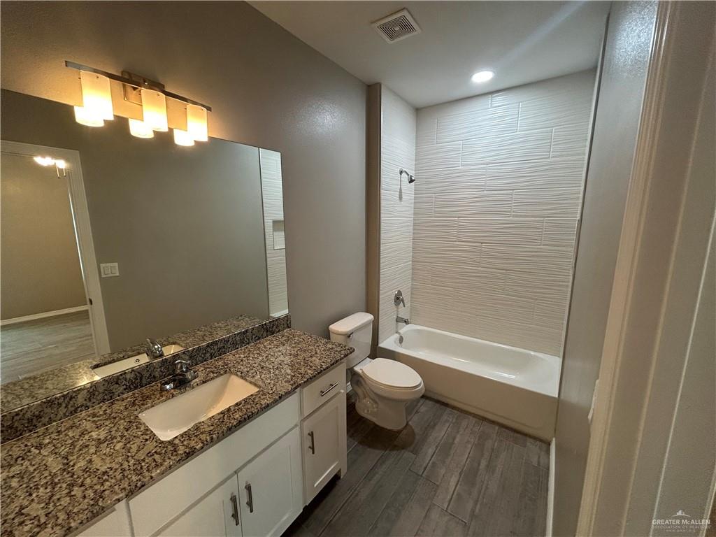 1805 Stauffers Street, Unit 1 Weslaco, TX 78596 - Photo 11 of 13 a bathroom with a granite countertop sink toilet and shower