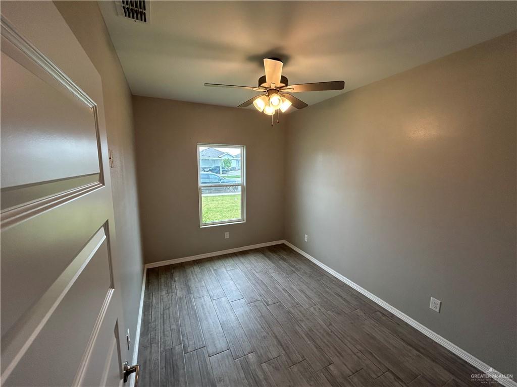 1805 Stauffers Street, Unit 1 Weslaco, TX 78596 - Photo 3 of 13 wooden floor in an empty room with a window