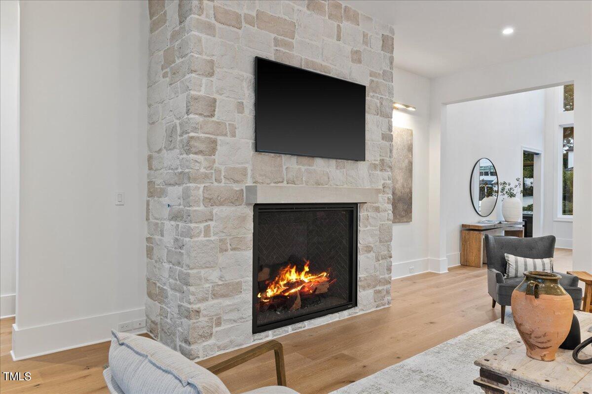 222 Reynolds Road Raleigh, NC 27609 - Photo 19 of 43 a living room with furniture a fireplace and a flat screen tv