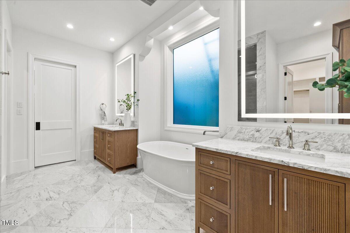222 Reynolds Road Raleigh, NC 27609 - Photo 20 of 43 a bathroom with a granite countertop tub sink and mirror
