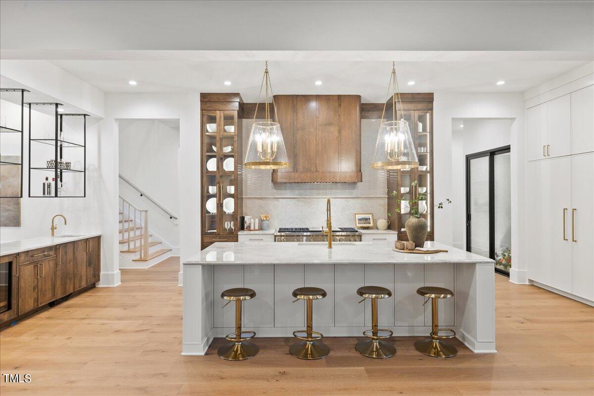 222 Reynolds Road Raleigh, NC 27609 - Photo 9 of 43 a kitchen with granite countertop a wooden floor and white cabinets