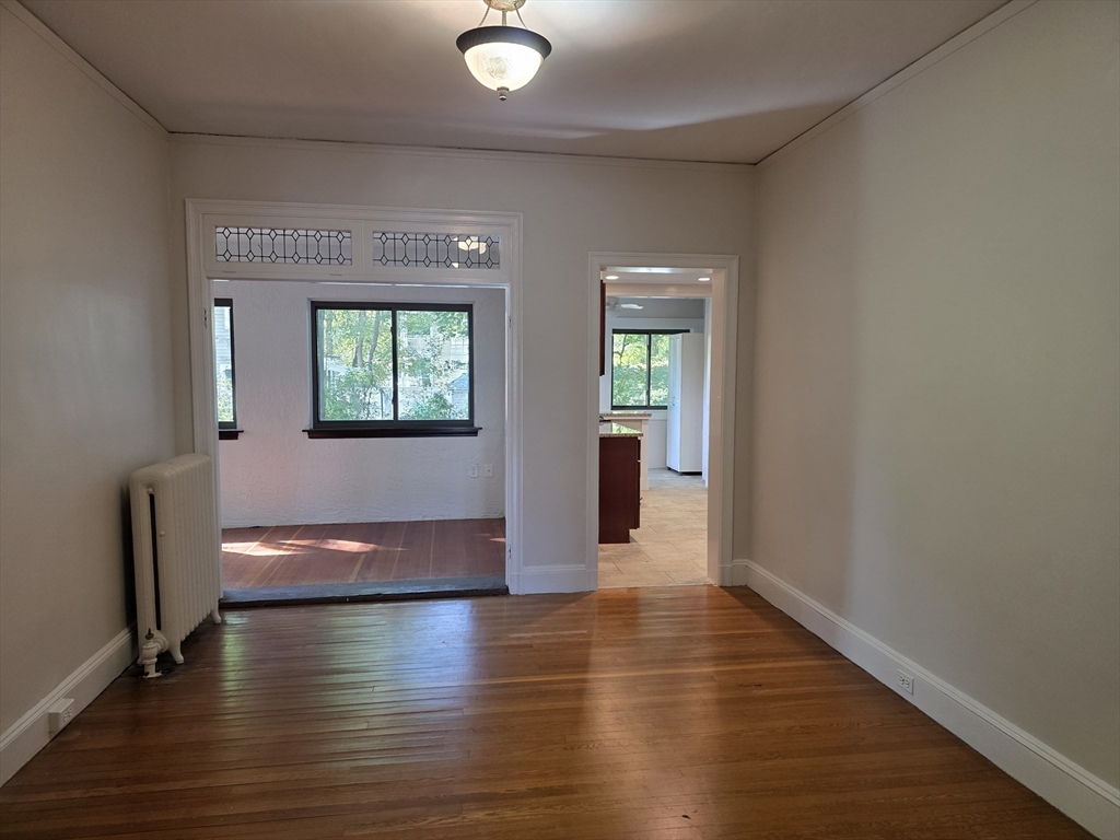7 Lewis Road, Unit 2 Winchester, MA 01890 - Photo 5 of 13 an empty room with wooden floor and a window