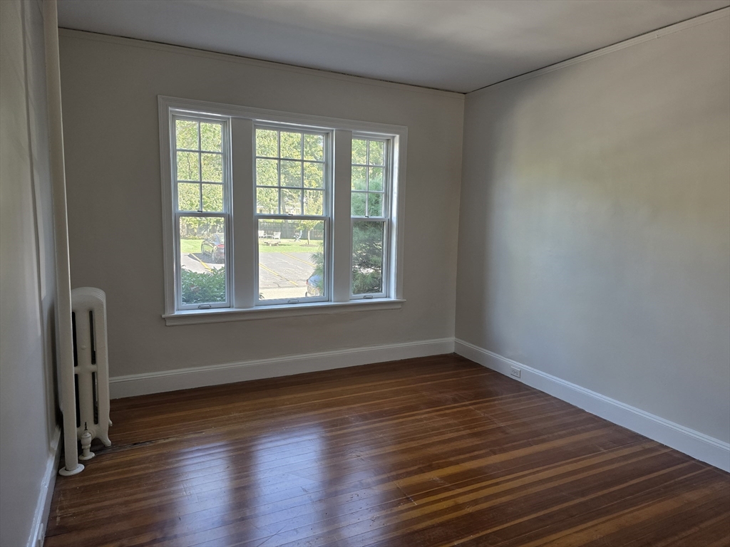 7 Lewis Road, Unit 2 Winchester, MA 01890 - Photo 7 of 13 an empty room with wooden floor and windows