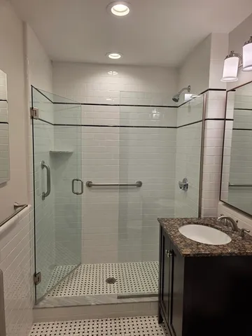 a bathroom with a sink a shower and a mirror