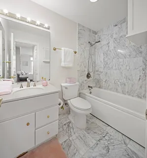 a bathroom with a toilet a sink a mirror a bathtub and shower