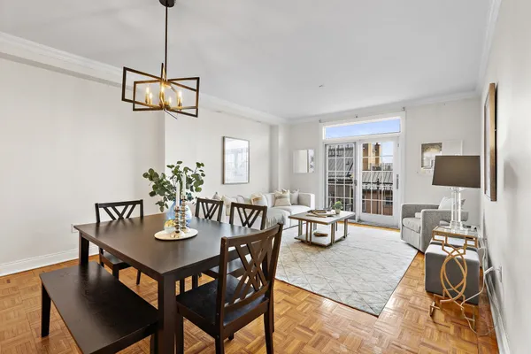 a dining room with furniture a chandelier and wooden floor