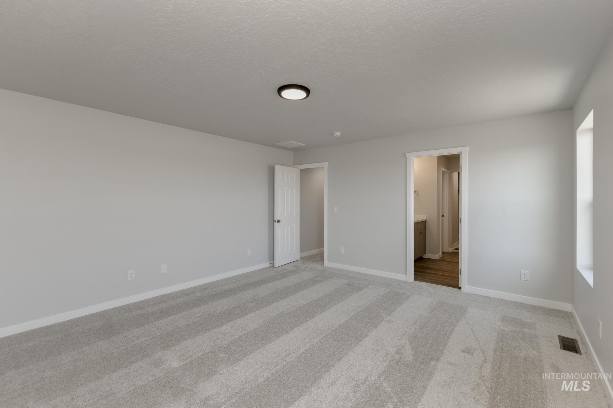 16366 Backfill Avenue Caldwell, ID 83607 - Photo 22 of 24 Unfurnished bedroom with light carpet and ensuite bath