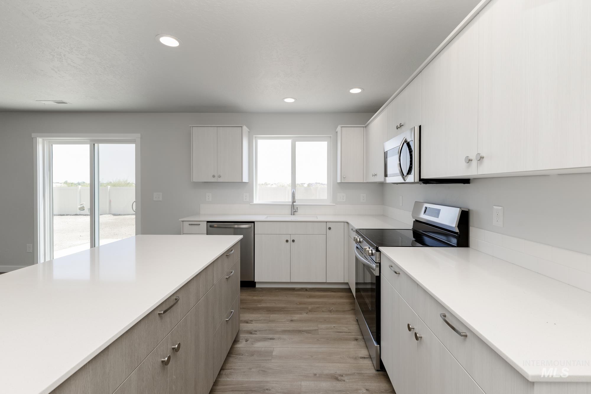 16366 Backfill Avenue Caldwell, ID 83607 - Photo 6 of 24 Kitchen featuring stainless steel appliances, light wood-style flooring, recessed lighting, white cabinetry, and modern cabinets