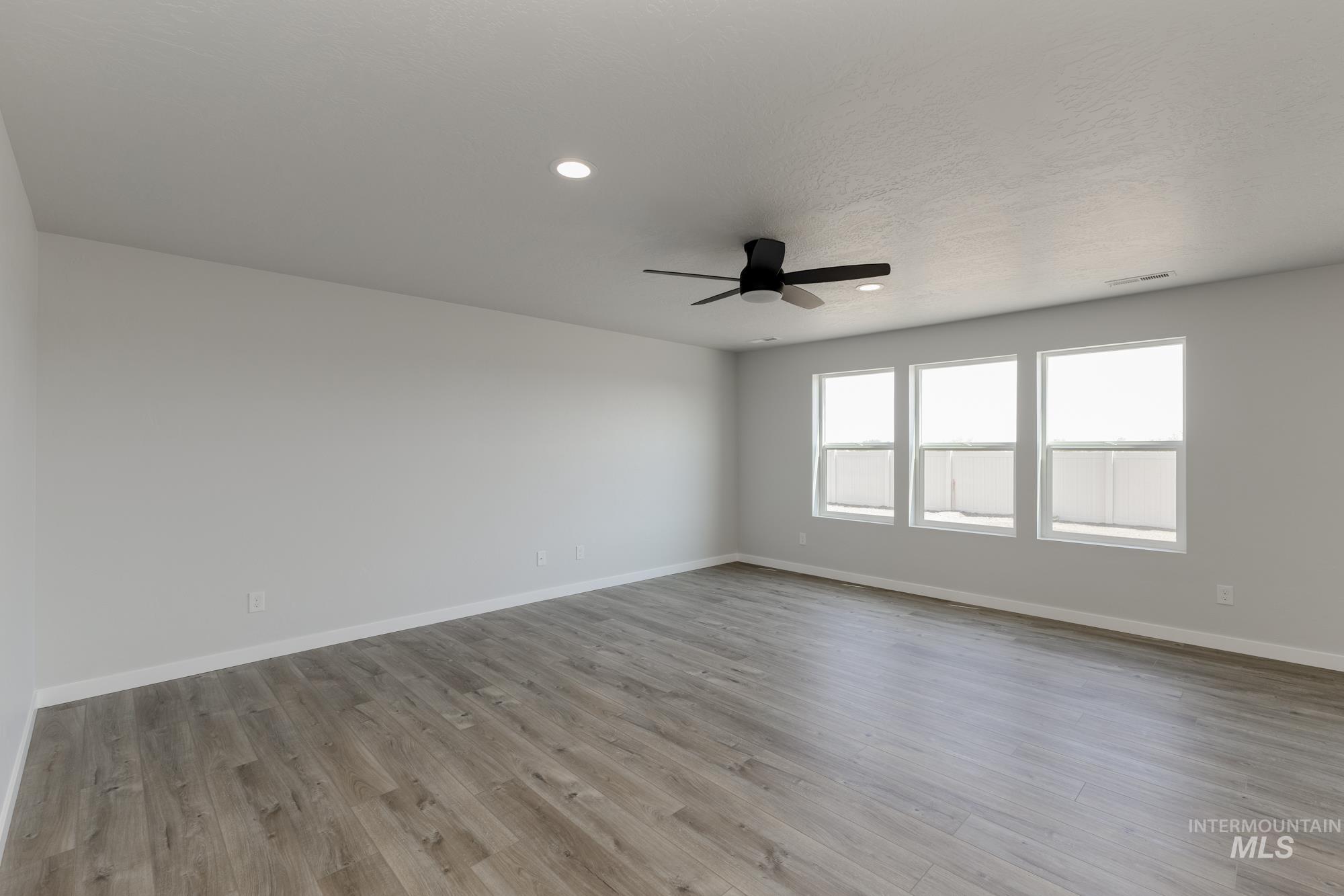 16366 Backfill Avenue Caldwell, ID 83607 - Photo 8 of 24 Unfurnished room with light wood-style floors, recessed lighting, and a ceiling fan