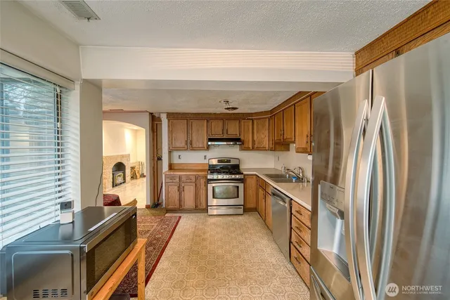 a kitchen with stainless steel appliances granite countertop a refrigerator and a stove top oven