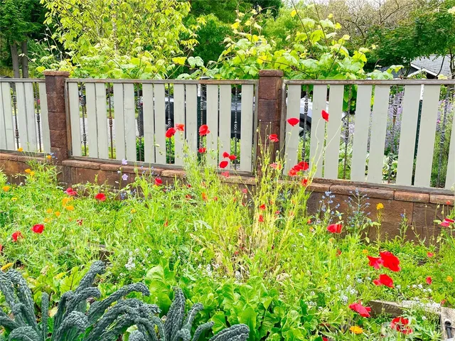 a view of flower garden with wooden fence